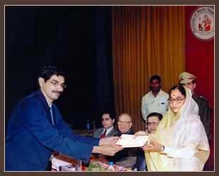 Dr. Narendra Kaushik receiving an award at a presentation with Pratibha Patil